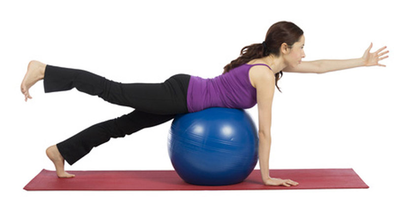 Young woman exercising with a pilates ball
